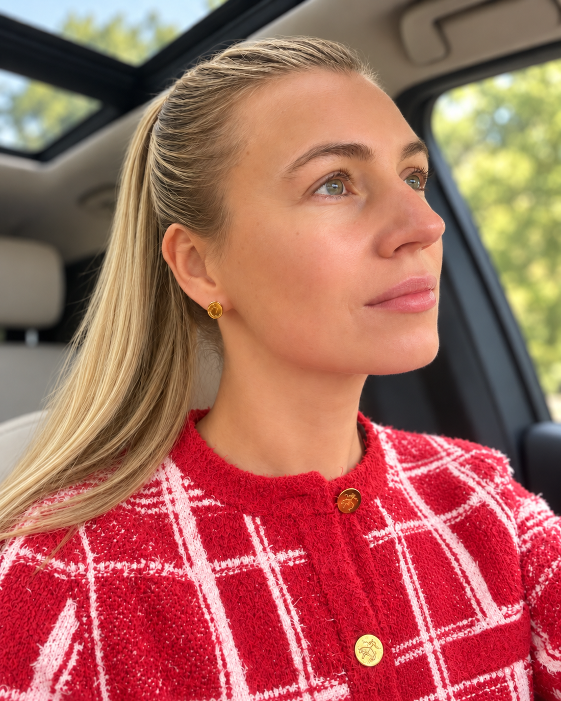 Woman wearing Baltic amber stud earrings with a red jacket for a polished everyday jewelry look